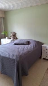 ein Schlafzimmer mit einem Bett, auf dem ein Teddybär liegt in der Unterkunft Saunallinen rivitalohuoneisto in Joensuu