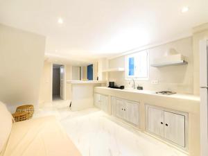 a white kitchen with a sink and a counter at 2-bedroom LOFT apartment in Megali Ammos