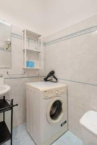 y baño con lavadora junto a un aseo. en Villa Rossa by Sicily Travelling Villas, en Scopello