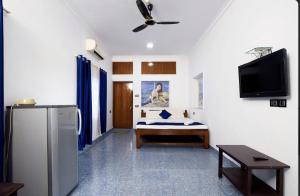 a room with a refrigerator and a bed in it at Marcelo Palace - Baga in Calangute