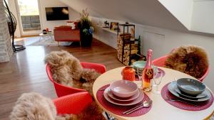 a table with red chairs and a table with hats and plates at Studio Dinkelberg in Adelhausen
