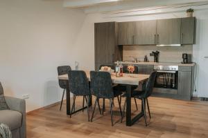 a kitchen with a table and chairs in a room at Ferienwohnung - LIVING Six in Eging