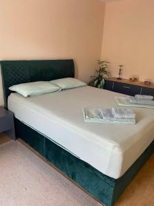 a bed with a green headboard and white sheets at Villa Mountain View in Janče