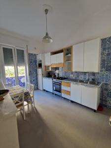 a kitchen with white cabinets and a table and a dining room at Casa Cristina in Maiori