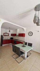 a kitchen with a table and chairs and red cabinets at Apartman Magdalena in Kastel Stafilic