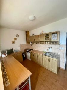 a kitchen with wooden cabinets and a wooden table at Ubytovanie Vlachovo in Vlachovo
