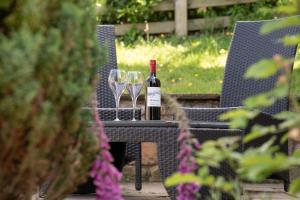 a table with a bottle of wine and two glasses at Ash Cottage, Castle Carrock, Nr Carlisle in Castle Carrock