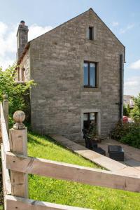a wooden fence in front of a brick house at Ash Cottage, Castle Carrock, Nr Carlisle in Castle Carrock