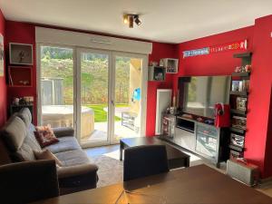 a living room with red walls and a television at Appartement cozy avec jacuzzi privé, Brignoles in Brignoles