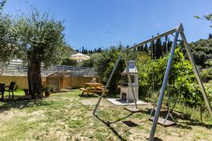a swing set in a yard with a table at Pasiphae Holiday Apartments in Kontokali