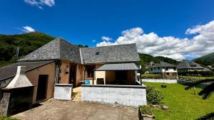 a house with a roof with a yard at L'école du Hameau 9pers Le Mont Dore in Le Mont-Dore
