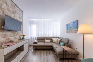 a living room with a couch and a tv at E-home Apartments in Varna City
