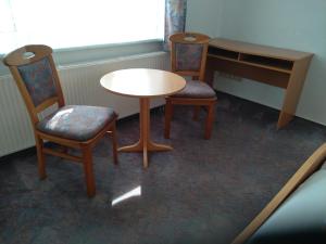 two chairs and a table in a room at Pension Christ in Waltershausen