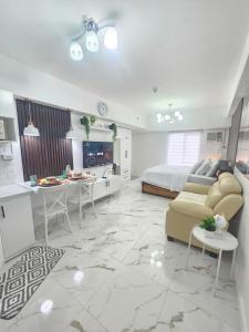 a living room with a bed and a couch and tables at Steff's Condo 722 at Centrio Tower in Cagayan de Oro