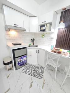 a white kitchen with a sink and a table at Steff's Condo 722 at Centrio Tower in Cagayan de Oro