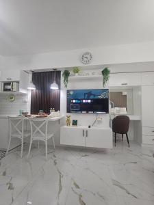 a white kitchen with a table and chairs and a tv at Steff's Condo 722 at Centrio Tower in Cagayan de Oro