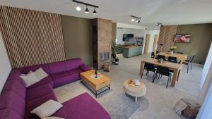 a living room with a purple couch and a table at Chalupa pod Cárinkou in Zboj