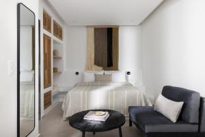Un dormitorio con una cama, una silla y una mesa. en Solmar Suites, en Agia Anna de Naxos 57 fotos más