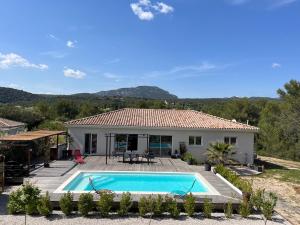 a villa with a swimming pool and a house at Paisible villa avec piscine proche du Pic Saint-Loup in Saint-Jean-de-Cuculles