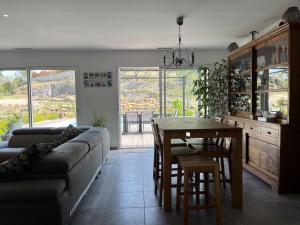 a living room with a couch and a table at Paisible villa avec piscine proche du Pic Saint-Loup in Saint-Jean-de-Cuculles