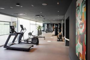 a gym with treadmills and ellipticals in a room at ARCOTEL AQ Wien in Vienna