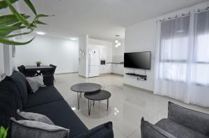 Ariston First Line Lake View في طبرية: غرفة معيشة بها أريكة وطاولة