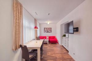 a living room with a table and a red couch at Ferienquartier- Forsthaus in Bad Gottleuba