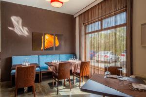 ein Restaurant mit Tischen und Stühlen und einem großen Fenster in der Unterkunft Hotel Sandalia in Nuoro
