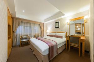 a hotel room with a large bed and a desk at Cosmos Hotel Taipei in Taipei +52 photos