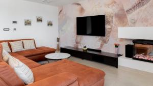 een woonkamer met een bank en een flatscreen-tv bij Villa Callista by Villas Holiday in Ružići