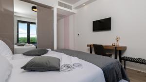 een slaapkamer met een bed, een bureau en een televisie bij Villa Callista by Villas Holiday in Ružići +32 foto's