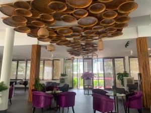 Una habitación con sillas moradas y un techo grande. en Villa biển nghỉ dưỡng Oceanami Long Hải, en Long Hai