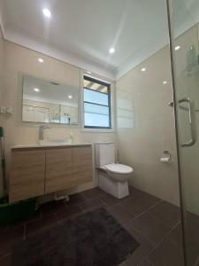 a bathroom with a toilet and a sink and a mirror at Spacious Queen Room with Private Balcony - GA4 in Chullora