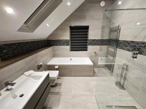 ein Badezimmer mit Badewanne, Waschbecken und Dusche in der Unterkunft Fyne Edge - A Luxurious Lochside Haven in Minard + 58 Fotos