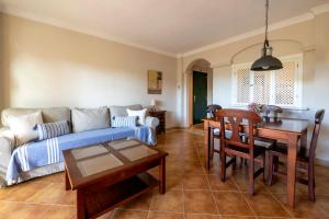 een woonkamer met een bank en een tafel bij apartamento campo de golf Isla Canela in Isla Canela
