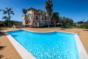 een groot zwembad voor een huis bij apartamento campo de golf Isla Canela in Isla Canela