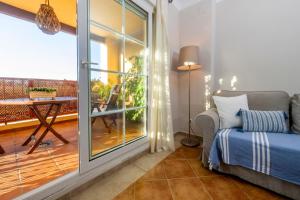 een kamer met een balkon, een bed en een raam bij apartamento campo de golf Isla Canela in Isla Canela