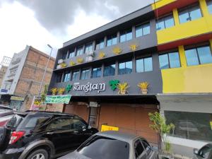 a santarchy building with cars parked in front of it at Songtam Hotel in Ipoh +10 photos