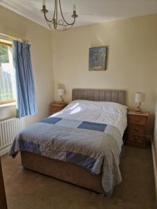 a bedroom with a bed and two night stands and a window at Farm House Cottage in Baltinglass