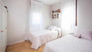 une chambre avec deux lits et une fenêtre dans l'établissement AG Casa Bértoa con jardín y comedor exterior x8, à Queo de Abaixo