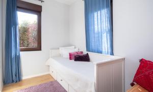 - une chambre avec un lit blanc et des rideaux bleus dans l'établissement AG Casa Bértoa con jardín y comedor exterior x8, à Queo de Abaixo