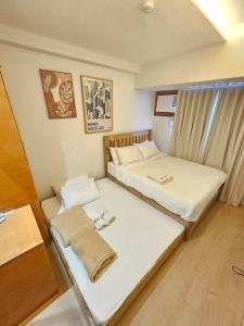 a room with two beds and a window at Steff's Condo 1708 one bedroom in Cagayan de Oro +1 photo