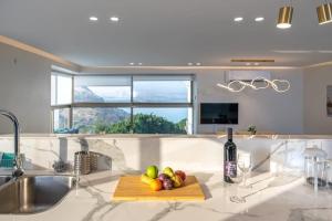 a kitchen with a cutting board with fruit on a counter at Luxury apartment with panoramic view in Tiberias