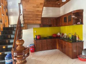 a kitchen with wooden cabinets and a yellow wall at Biệt Thự Villa Thảo Vy in Ly Son