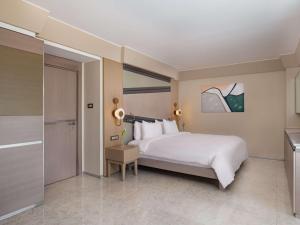 a bedroom with a large white bed and a table at Rixos Premium Tekirova - The Land of Legends Access in Tekirova
