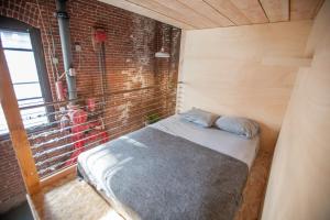 a bed in a room with a brick wall at PodShare DTLA in Los Angeles