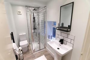 a white bathroom with a sink and a shower at Hawley Apartment - City Centre - Free Parking, Self-Check-In, Fast Wifi and Smart TV by Yoko Property in Sheffield +9 photos