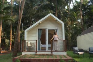 a woman standing on the porch of a tiny house at Sea Breeze, Guhagar in Guhagar