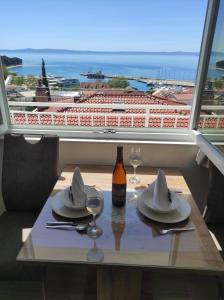 a table with two glasses and a bottle of wine at Apartment Topic in Baška Voda