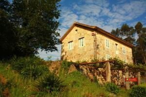 an old stone building sitting on a hill at Casa de Turismo Rural Os Petroglifos in Boiro